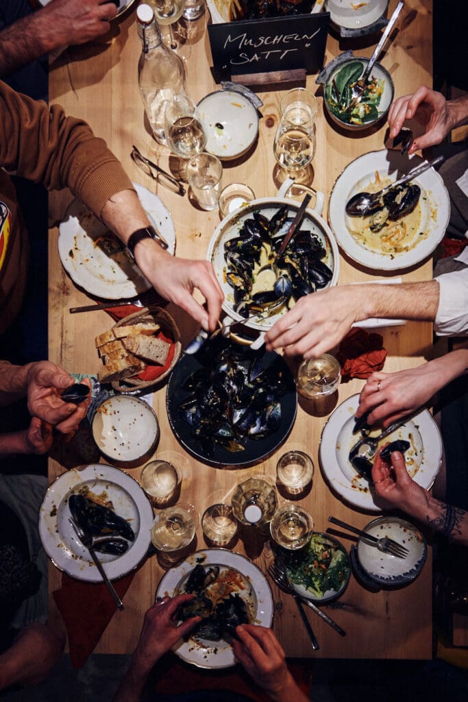 Lange Tafel mit Schüsseln voller Muscheln beim Muschelessen in der Alten Schmiede